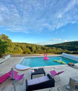 una piscina con 2 sillas y un flotador rosa en Maison d'hôtes à la Ferme Une Pause à la Guette, en Uxeau