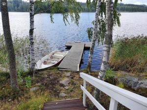 a dock with a boat on the shore of a lake at Tarula Holiday Home in Melkoniemi