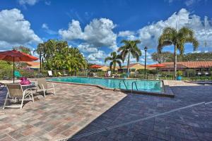 a swimming pool with a table and chairs and palm trees at Cozy Naples Retreat 1 Mi to Vanderbilt Beach in Naples