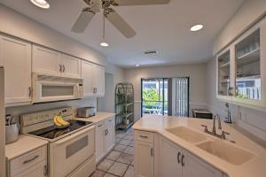 cocina con armarios blancos y ventilador de techo en Cozy Naples Retreat 1 Mi to Vanderbilt Beach, en Naples