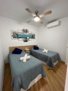 1 dormitorio con 2 camas y ventilador de techo en Remolars Sevilla, en Sevilla