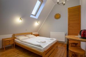 a small bedroom with a bed and a table at Willa pod Szrenicą in Szklarska Poręba