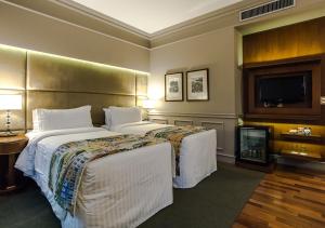 a hotel room with two beds and a flat screen tv at Gran Estanplaza Berrini in Sao Paulo