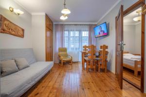 a living room with a bed and a dining room at Willa pod Szrenicą in Szklarska Poręba