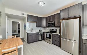 a kitchen with wooden cabinets and a stainless steel refrigerator at Forest park, Science Center, BJC & CWE restaurants in Tower Grove