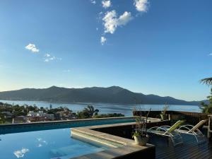 a swimming pool with a view of the water at Aloha spa in Florianópolis