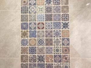 una pared de azulejos con un montón de azulejos de diferentes colores en Maison Blanche en Côte de Nacre, en Mathieu 26 fotos más