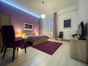 a bedroom with a bed and a tv and a chair at ABT Apartments Karoly in Budapest
