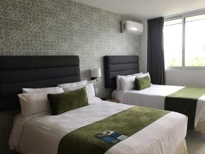 una camera d'albergo con due letti e una finestra di Hotel Ros Gaud a Córdoba