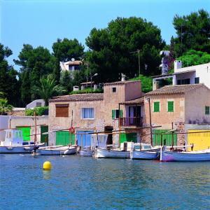 a group of boats in the water near houses at Hostal San Francisco in Cala d´Or