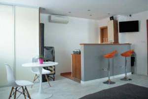 Zimmer mit 2 Stühlen, einem Tisch und einer Theke in der Unterkunft Apartmán - Dlhé Diely in Bratislava