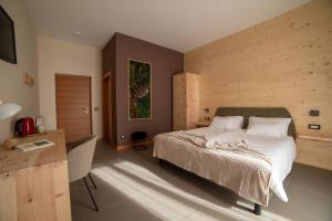 a bedroom with a bed and a wooden wall at Bosc del Meneghì in Ledro