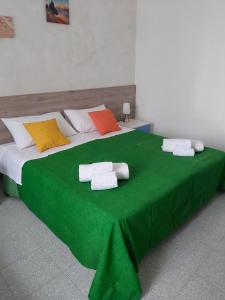 a large green bed with towels on top of it at Case Costa Degli Dei in Santa Domenica