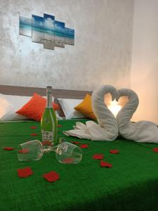 a bed with two swan towels and a bottle of champagne at Case Costa Degli Dei in Santa Domenica