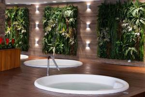 a bathroom with three sinks with plants on the wall at Bella Gramado Resort & Spa by Gramado Parks in Gramado