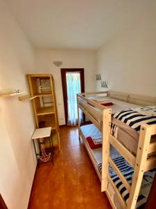 アリエントゥにあるTrilocale Vignola Mareのベッドルーム1室(二段ベッド2組付)