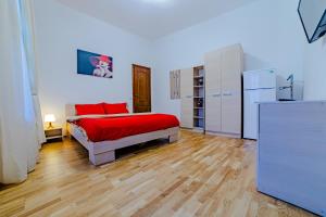 Schlafzimmer mit einem roten Bett und einem Kühlschrank in der Unterkunft Old City Lux 2 in Braşov