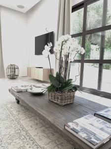 un soggiorno con tavolo e vaso di fiori di Luxury Home Sweet Home Mougins a Mougins