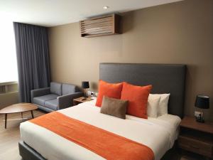 a bedroom with a large bed with orange pillows at Hausuites in Mexico City