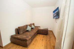 a living room with a brown couch in a room at Alpenherz in Filzmoos