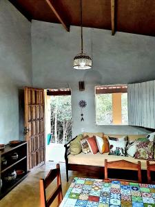 a living room with a couch and some windows at Espaço Terra Dourada, Ibicoara, Chap Diamantina in Ibicoara