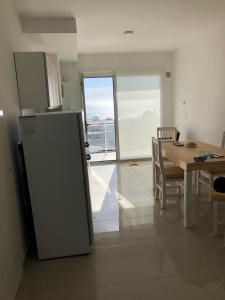 een keuken met een koelkast en een tafel met stoelen bij Departamento Centrico VDL in Puerto Madryn