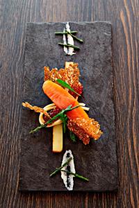 a black plate with some food on a table at Hotel Svanen Billund in Billund