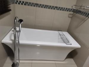 a white bath tub in a bathroom with a shower at Erins Haven - Polokwane in Polokwane