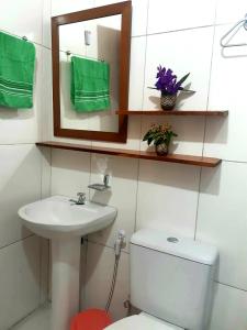 a bathroom with a toilet and a sink and a mirror at Espaço Terra Dourada, Ibicoara, Chap Diamantina in Ibicoara