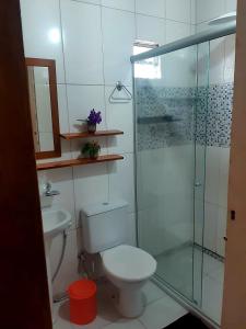 a bathroom with a toilet and a glass shower at Espaço Terra Dourada, Ibicoara, Chap Diamantina in Ibicoara