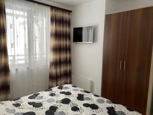 a bedroom with a bed with a black and white blanket at Апартамент в комплекс Смолянски езера in Smolyan +10 photos