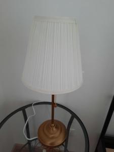 una lámpara con una sombra blanca sobre una mesa en Frankie’s House, en Ghiffa