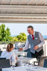 Ein Mann im Anzug und eine Krawatte mit einem Glas Wein. in der Unterkunft Kora Park Resort in Formia