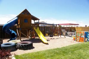 un parque infantil con tobogán y una casa de juegos en Country Cabins Inn, en Lyman
