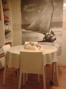 une table blanche avec des chaises et un voilier sur un tableau dans l'établissement Su Planu, à Cagliari