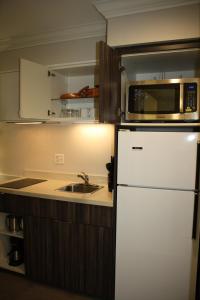 a kitchen with a white refrigerator and a microwave at Executive Suites Hotel & Conference Center, Metro Vancouver in Burnaby