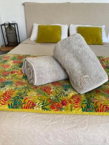 Una cama con dos almohadas y una manta. en LA POINTE D’ASPRETTO en Ajaccio