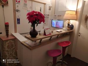 a desk with a vase of flowers and two red stools at Art And Relax Suites in Rome