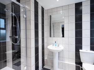 a bathroom with a sink and a shower and a toilet at Old Posting House in Cockermouth