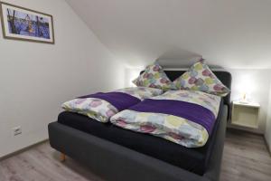 a bed with pillows on it in a room at Ferienkate Norddeich in Norddeich