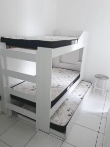 einen weißen Schrank mit einer Arbeitsplatte in einem Zimmer in der Unterkunft Apartamento com piscina em Ubatuba-SP in Ubatuba