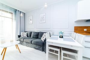 ein Wohnzimmer mit einem Sofa und einem Tisch in der Unterkunft Bright - Neptun Park by OneApartments in Danzig
