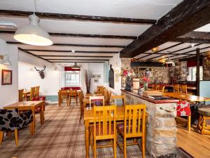 a restaurant with wooden tables and wooden chairs at Old Posting House in Cockermouth