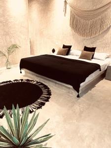 1 dormitorio con 1 cama y una maceta en Apartments & Suites MADRE Holbox Self-Check IN en Holbox Island