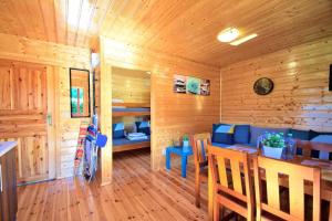 a room with a wooden cabin with a table and chairs at Domki Letniskowe Bursztynek in Dąbki