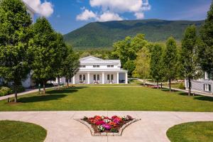 a large white house with a lawn and flowers at The Equinox Golf Resort & Spa in Manchester