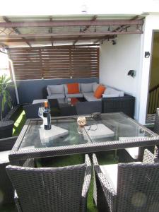 a patio with a glass table and chairs and a couch at Cosy Garden 2 in Flic-en-Flac