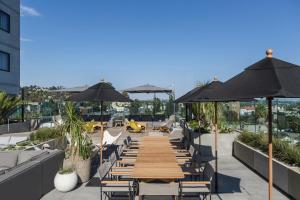 a patio with tables and chairs and umbrellas at Kimpton Everly Hotel Hollywood, an IHG Hotel in Los Angeles