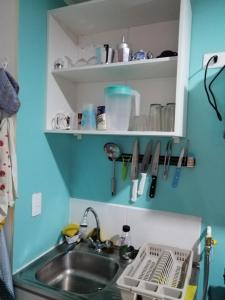 een aanrecht met een wastafel en een plank met keukengerei bij DEPTO EN PUERTAS DEL MAR in La Serena