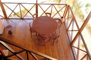 an overhead view of a wooden table and chairs at 2 bedrooms house at Cap Skirring 50 m away from the beach with sea view furnished terrace and wifi in Kabrousse